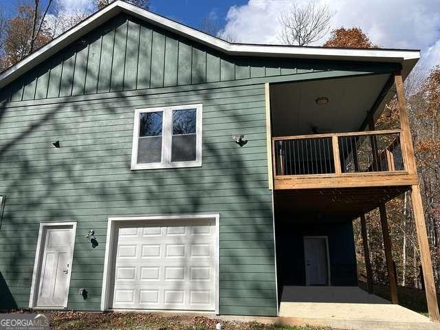 back of property featuring a balcony and a garage