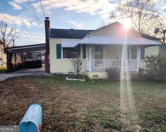 bungalow with a front yard, a porch, and a carport