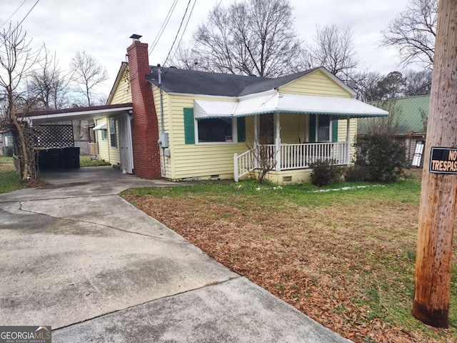 bungalow-style home featuring a carport, a porch, and a front yard