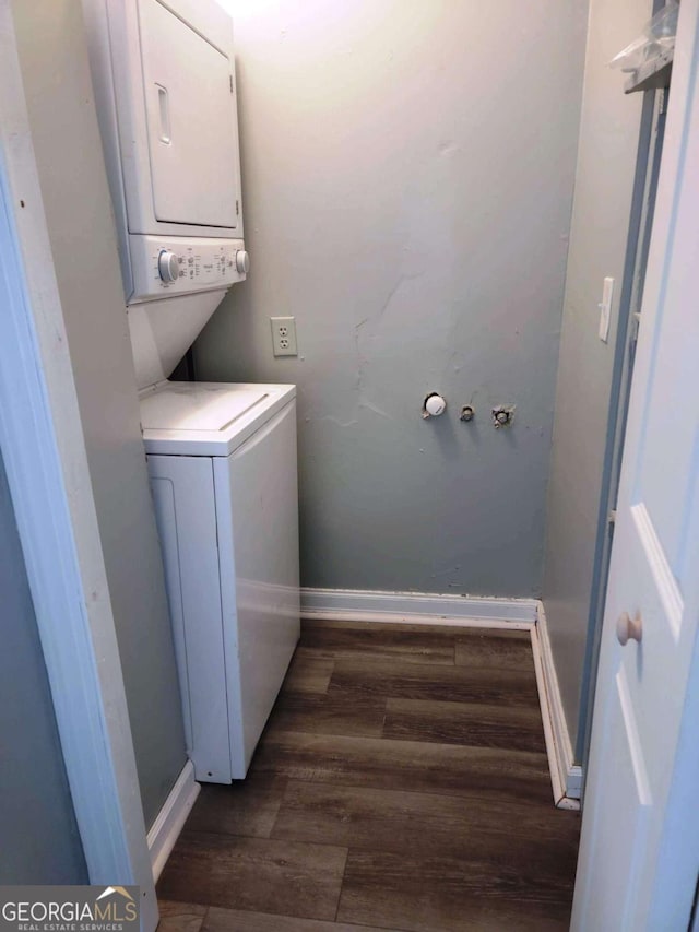 washroom featuring stacked washing maching and dryer and dark hardwood / wood-style floors