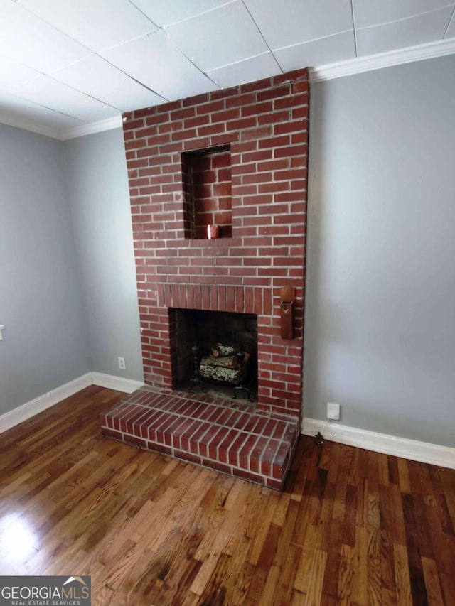 unfurnished living room featuring ornamental molding, a fireplace, and wood-type flooring