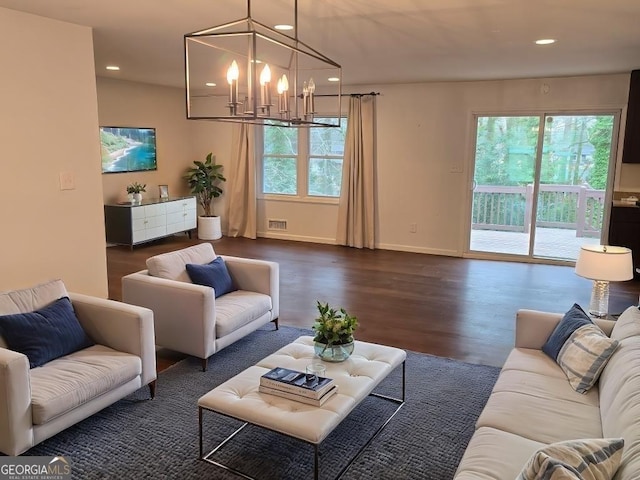 living room featuring a notable chandelier and dark wood-type flooring