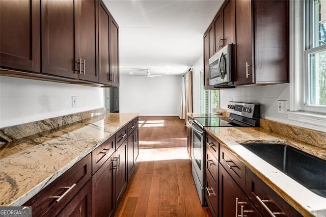 kitchen with appliances with stainless steel finishes, ceiling fan, hardwood / wood-style floors, and a wealth of natural light