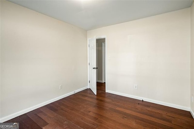 spare room with dark wood-type flooring