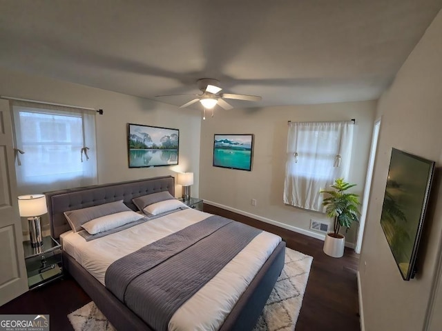 bedroom with dark hardwood / wood-style flooring and ceiling fan