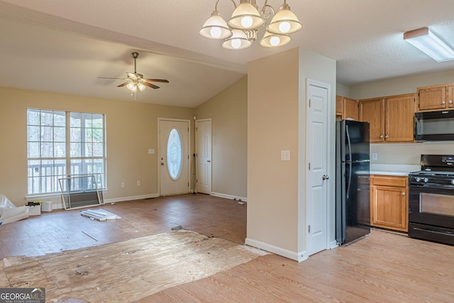 kitchen with decorative light fixtures, light hardwood / wood-style floors, and black appliances