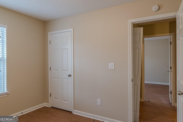 unfurnished bedroom featuring a textured ceiling and light hardwood / wood-style floors