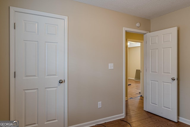 bedroom featuring hardwood / wood-style floors and a textured ceiling