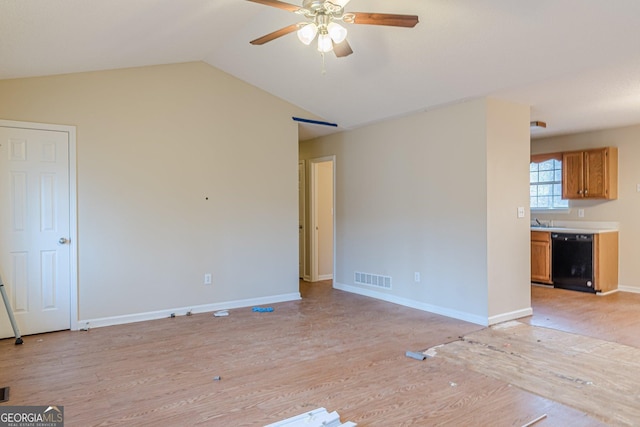 empty room featuring sink, vaulted ceiling, ceiling fan, and light wood-type flooring