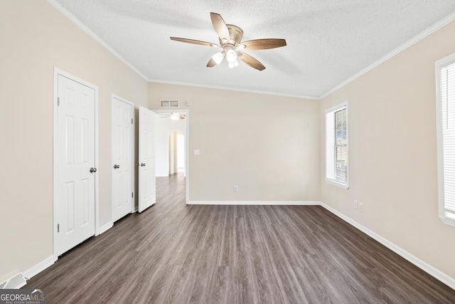 unfurnished bedroom with ceiling fan, dark wood-type flooring, two closets, and a textured ceiling