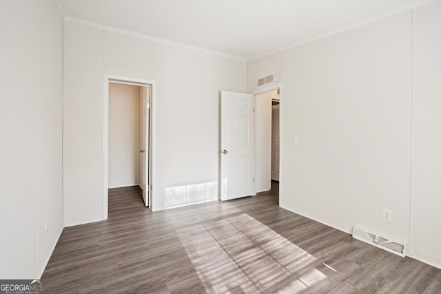 unfurnished bedroom with ornamental molding and wood-type flooring