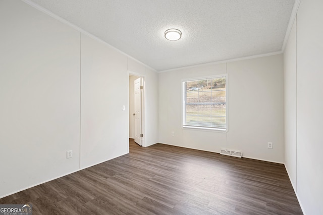 empty room with ornamental molding, dark hardwood / wood-style flooring, and a textured ceiling