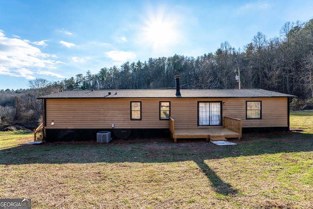 back of property with central AC unit, a lawn, and a wooden deck