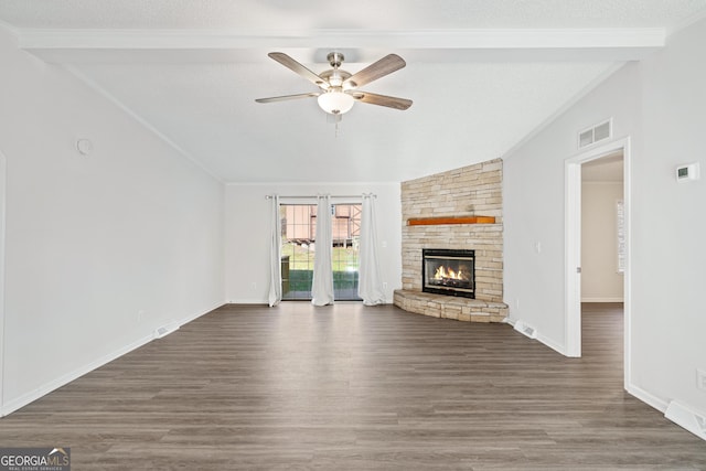 unfurnished living room with ceiling fan, a stone fireplace, vaulted ceiling with beams, and dark hardwood / wood-style floors