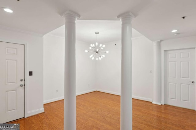 foyer with crown molding, wood-type flooring, and a notable chandelier