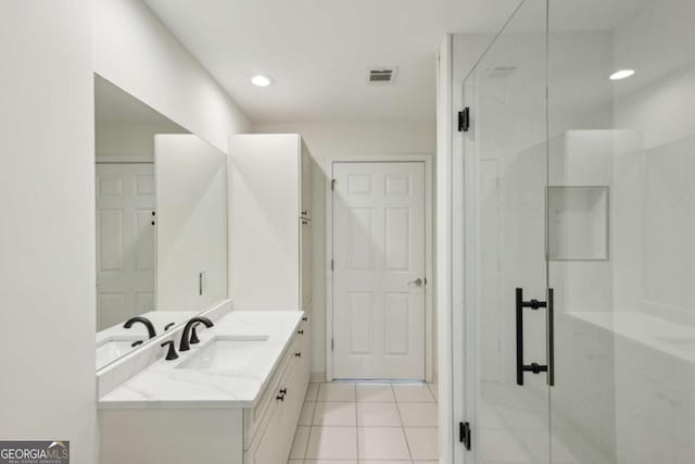 bathroom featuring tile patterned flooring, vanity, and a shower with shower door