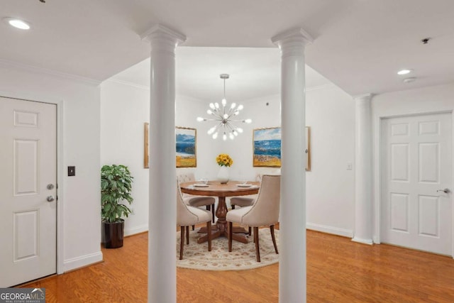 dining area featuring hardwood / wood-style flooring, ornamental molding, and an inviting chandelier