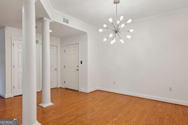 50 Biscayne Dr Unit 2109, Atlanta, GA 30309 - unfurnished dining area with decorative columns, ornamental molding, light wood-style flooring, a chandelier, and baseboards