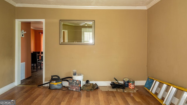 spare room featuring hardwood / wood-style flooring and crown molding