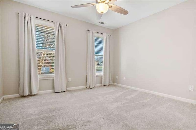 empty room featuring light colored carpet and ceiling fan