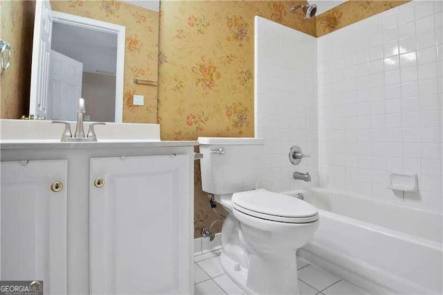 full bathroom featuring tile patterned floors, tiled shower / bath, vanity, and toilet