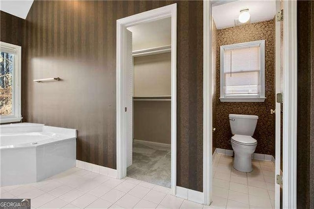 bathroom featuring a tub, tile patterned flooring, and toilet