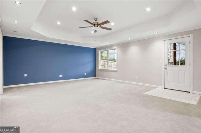 carpeted spare room featuring ceiling fan, crown molding, and a tray ceiling