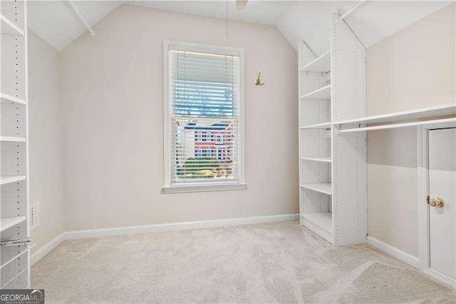 spacious closet with light carpet and lofted ceiling