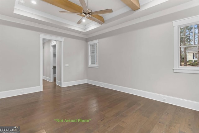 spare room with ceiling fan, dark hardwood / wood-style floors, beamed ceiling, and a tray ceiling