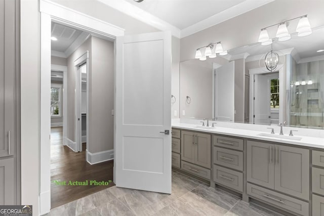 bathroom featuring vanity, crown molding, and a notable chandelier