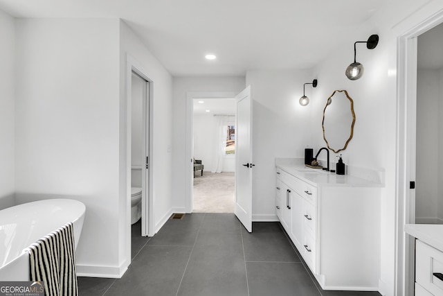 bathroom featuring vanity, toilet, and a tub