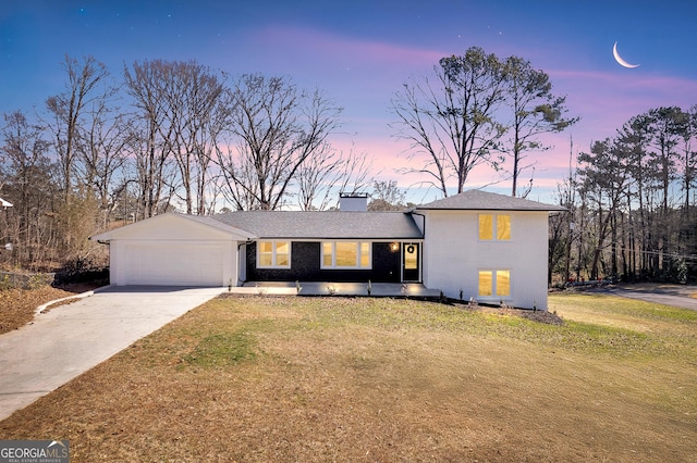 view of front of property with a garage and a yard