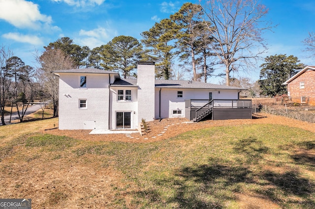 rear view of property featuring a deck and a yard