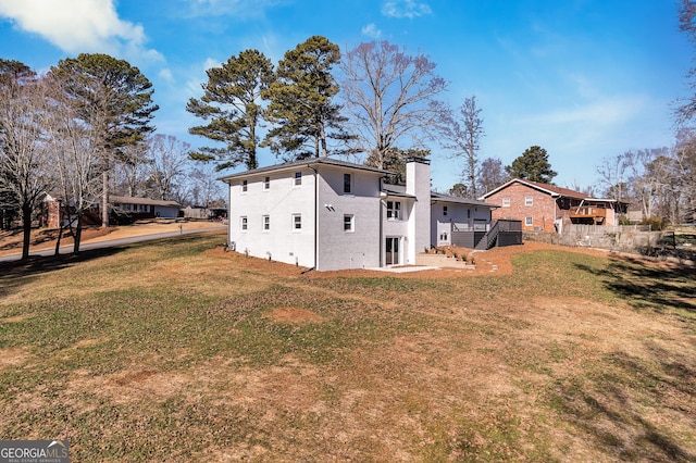 rear view of house with a lawn and a deck