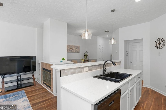 kitchen featuring a center island with sink, pendant lighting, white cabinets, and a sink