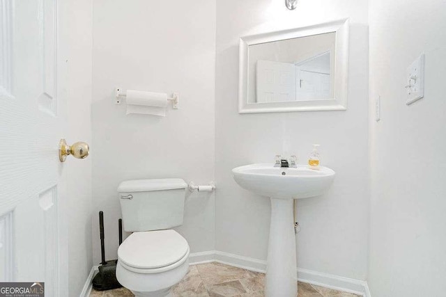 bathroom with toilet and baseboards