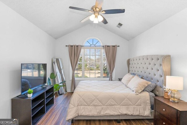 bedroom featuring ceiling fan, light wood-type flooring, a textured ceiling, and lofted ceiling