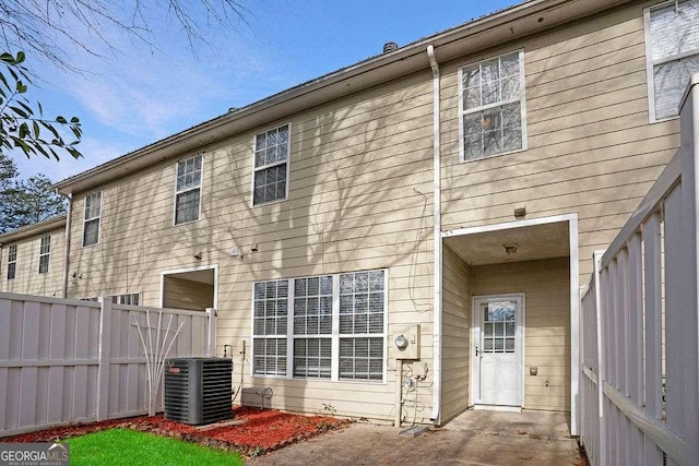 back of house featuring central AC unit and fence