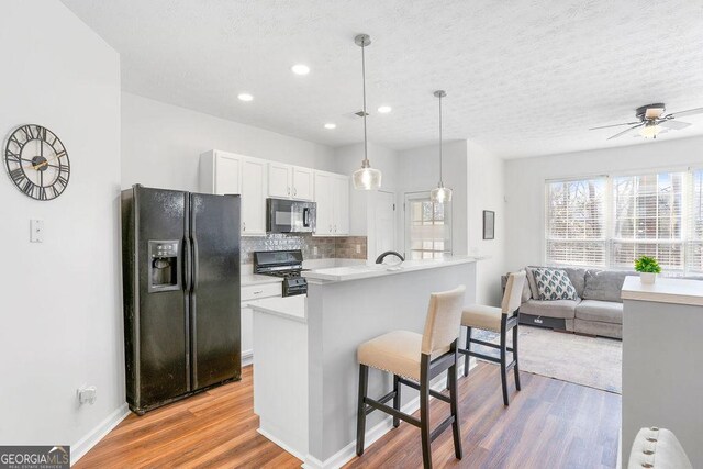 dining area featuring wood-type flooring and a textured ceiling