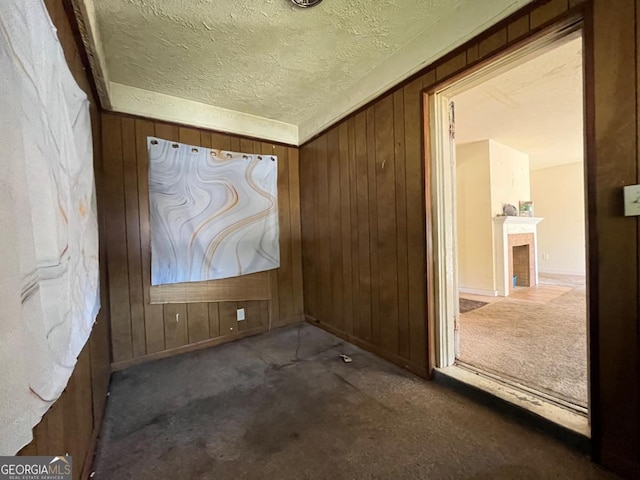 carpeted empty room with wood walls