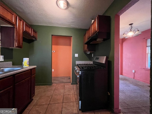 kitchen with black gas stove, a chandelier, a textured ceiling, decorative light fixtures, and light tile patterned floors