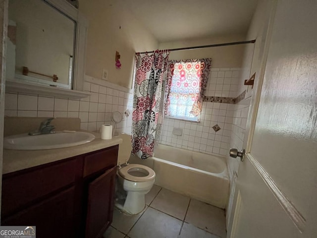 full bathroom featuring tile patterned floors, shower / bath combination with curtain, toilet, vanity, and tile walls