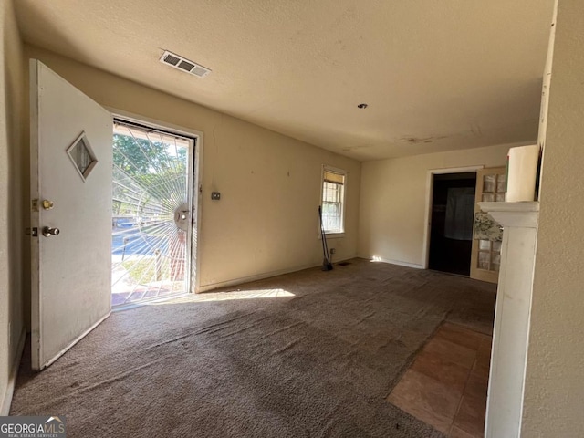 interior space with a fireplace, a textured ceiling, and carpet floors