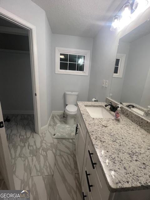 bathroom featuring vanity, toilet, and a textured ceiling