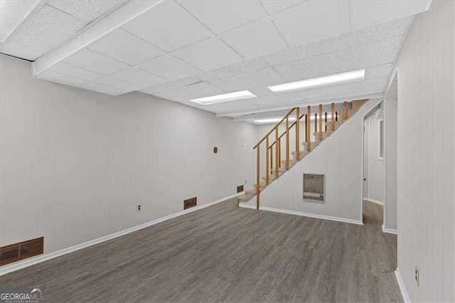 basement with a paneled ceiling and hardwood / wood-style floors