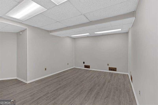 empty room featuring hardwood / wood-style floors and a drop ceiling