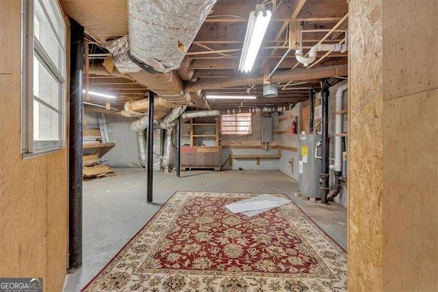 basement featuring electric panel and water heater