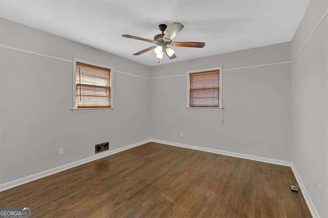 empty room with dark hardwood / wood-style floors and ceiling fan