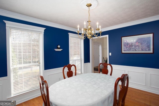 dining room featuring hardwood / wood-style floors, crown molding, and a healthy amount of sunlight