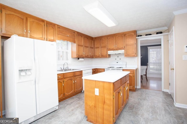 kitchen featuring sink, backsplash, a center island, crown molding, and white appliances